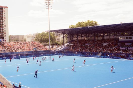 Televisiescherm in Amsterdams sportcafé met nos live olympische spelen en kijkers op de achtergrond