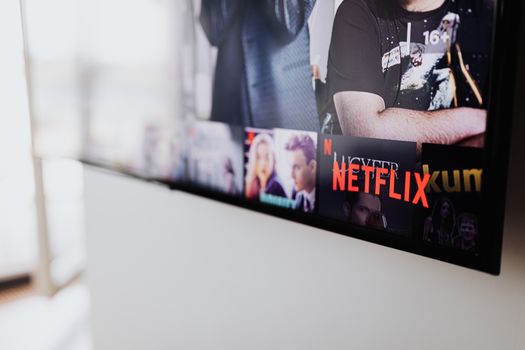 Tv-scherm met populaire Netflix-series van 2026, afstandsbediening en snacks voor een binge-avond