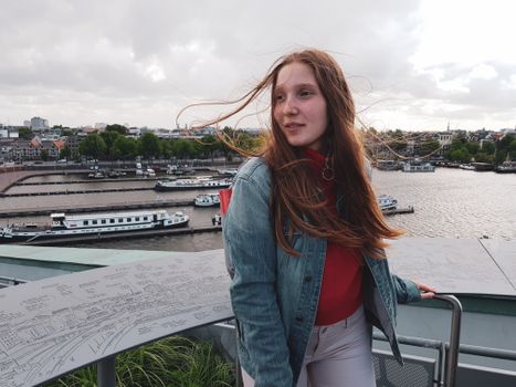 Stijlvol portret van een influencer met smartphone in een moderne stedelijke setting in Noord-Holland